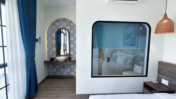 A modern bathroom with a large mirror, a sink, and a shower area.