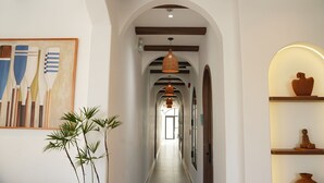 A hallway with an arched ceiling, wooden beams, a hanging light fixture, and a framed artwork on the wall. - Hotel SHOL Ninh Chu (Ninh Chu)