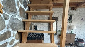 A wooden staircase with a stone wall on one side. - Charming 3-bedroom B&B in serene Manali perfect for getaway (Naggar)