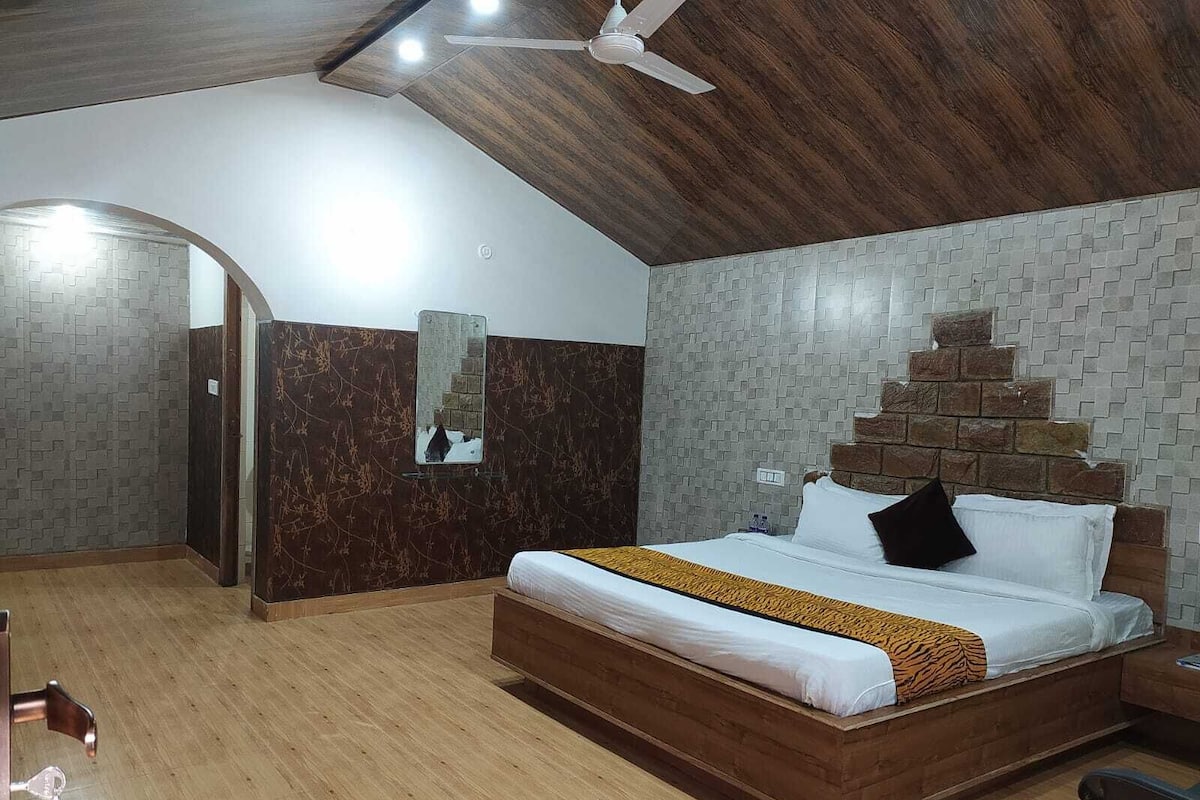 A bedroom with a wooden bed, a ceiling fan, and a brick-patterned wall.