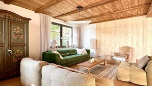 A cozy living room with a green sofa, a wooden coffee table, and a green armchair. - Holiday Villa With Sauna, on the Shore of the Lake (gmina Osiek)