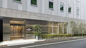 Un bâtiment moderne avec une entrée en verre, une enseigne indiquant « WAYPOINT », et un pot de fleurs à l’extérieur.