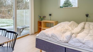 A bedroom with a bed, a desk, and a chair. There is a window with a view of trees and a fence. - 4 bedroom beautiful home in Knebel (Knebel)