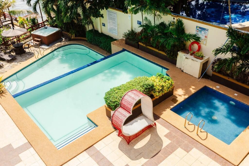Una piscina con hidromasaje, sillas de descanso y una pequeña terraza.