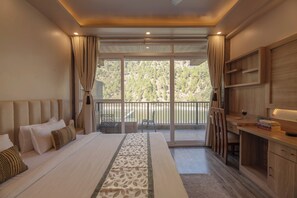 A modern bedroom with a large bed, a desk, and a balcony with a view of trees. - Alaya Stays Lakefront Escape 2BHK Suite (Nainital)