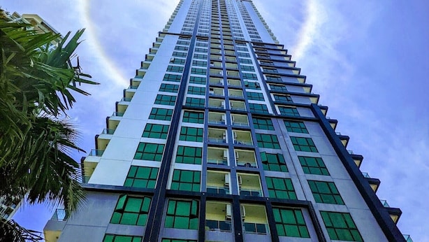 Un edificio alto y moderno con un diseño luminoso circular en el cielo.