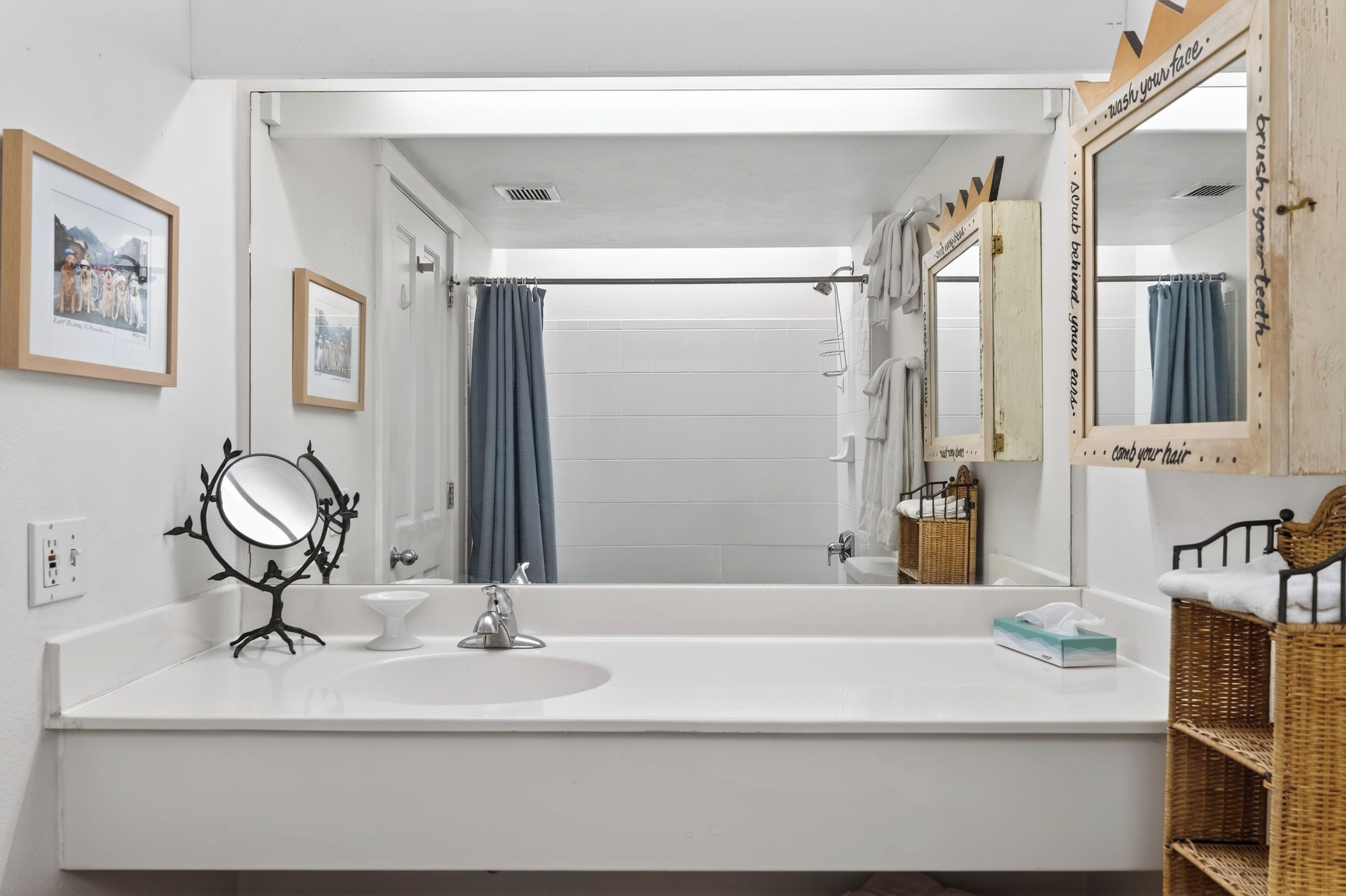 A bathroom with a white sink, a mirror, a towel rack, and a shower curtain.