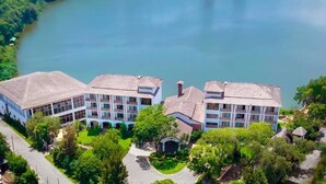 Un hôtel doté d’une cour intérieure, entourée d ’une végétation luxuriante et bordé d’un lac.