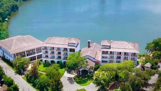 A hotel with a central courtyard, surrounded by lush greenery and a lake. - Noora Resort (Bishoftu)