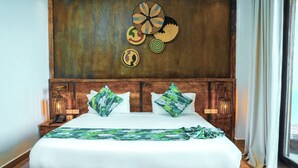 A large bed with a wooden headboard, two green patterned pillows, and a white bedspread. - Noora Resort (Bishoftu)