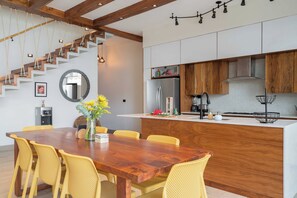 Eine moderne Küche mit Holzausbau, einem Edelstahlkühlschrank und einer integrierten Kücheninsel.
