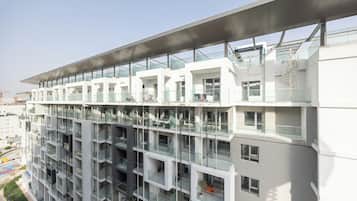 Um edifício residencial com vários andares, varandas, grandes janelas e um design arquitetônico moderno.