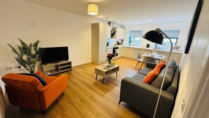 Una sala de estar moderna con un sofá, televisor y una mesa de centro.