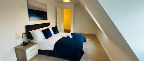 A bedroom with a bed, nightstand, and a painting on the wall.