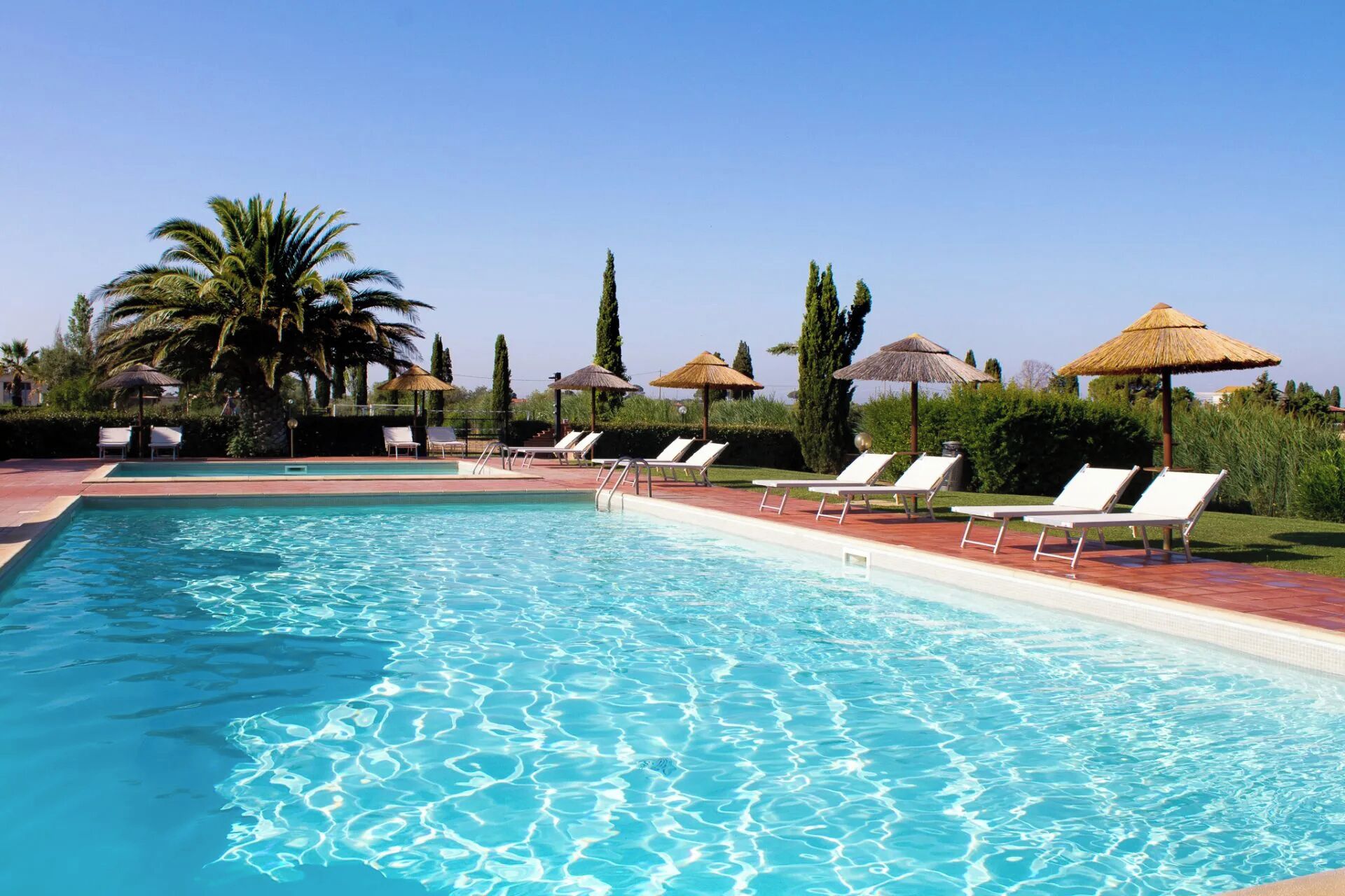 季節性室外游泳池，提供泳池遮陽傘和日光浴躺椅