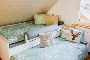 Una camera da letto in stile loft con soffitto a falde, un letto con biancheria da letto floreale e una finestra con vista.