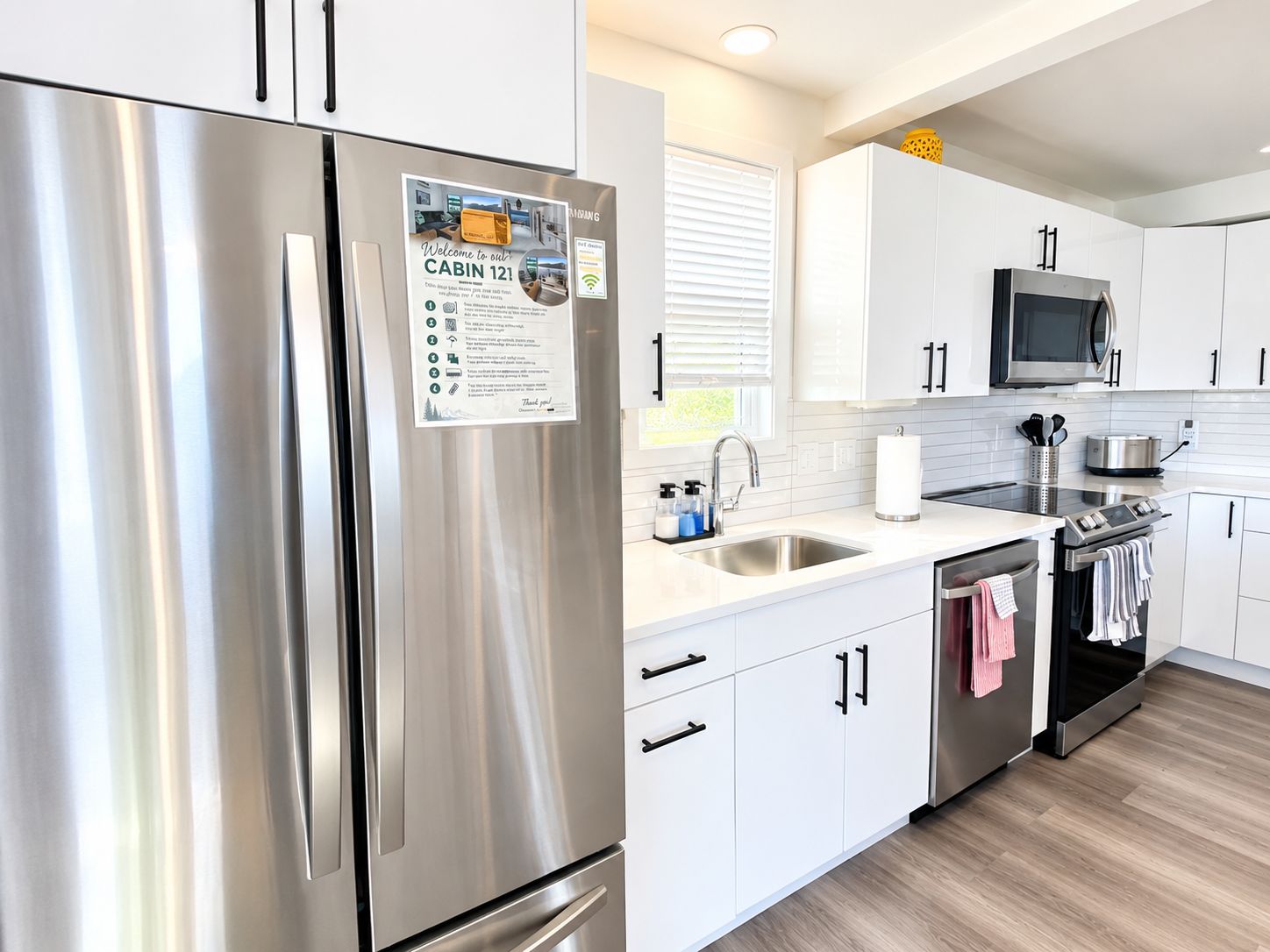 A modern kitchen with stainless steel appliances, white cabinetry, and a built-in oven.