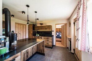 Una cucina moderna con mobili in legno, una macchina da caffè e luci a sospensione.