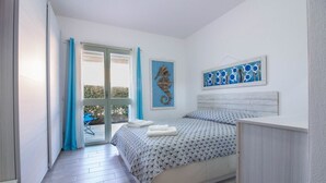 Quarto com cama, janela com cortinas, obra de arte na parede e vista para o exterior.