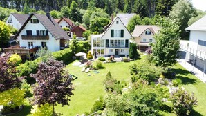 A residential area with houses, a well-maintained lawn, and a swimming pool. - Villa Wolfsgrund – 5-Star Luxury Design Holiday Home (Schluchsee)