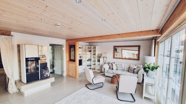 A spacious living area with a wooden ceiling, a sofa set, a coffee table, and a bookshelf. - Villa Wolfsgrund – 5-Star Luxury Design Holiday Home (Schluchsee)