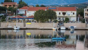 Zona costera con edificios, un muelle y barcos.
