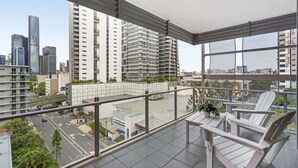 A balcony with a view of a cityscape, including tall buildings and a road. - Central Apartment with Rooftop Pool & Views (South Brisbane)