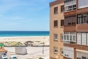 A coastal building with multiple windows, a beach view, and a clear sky. - Lances Sun | Modern apartment facing Los Lances Beach, ideal for 4 guests (Tarifa)