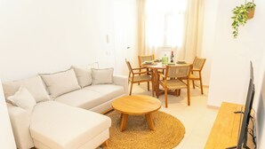 Un salon moderne comprenant un canapé, une table basse et une table à manger avec des chaises.