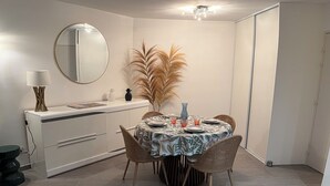 Ruokailutila, jossa on pyöreä pöytä, tuoleja, peili ja kattotuuletin.