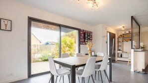 Eine moderne Küche mit Essbereich, großen Fenstern und Blick ins Freie.