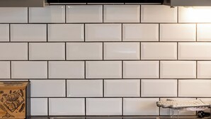 A kitchen with white subway tiles, a black range hood, and a stainless steel oven. - 🏡 Paradiso Apartment | Full Air Conditioning • Outdoor Space • Near Corfu Town (Ionian Islands)