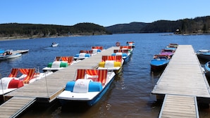 Un muelle con barcos y sillas de descanso.