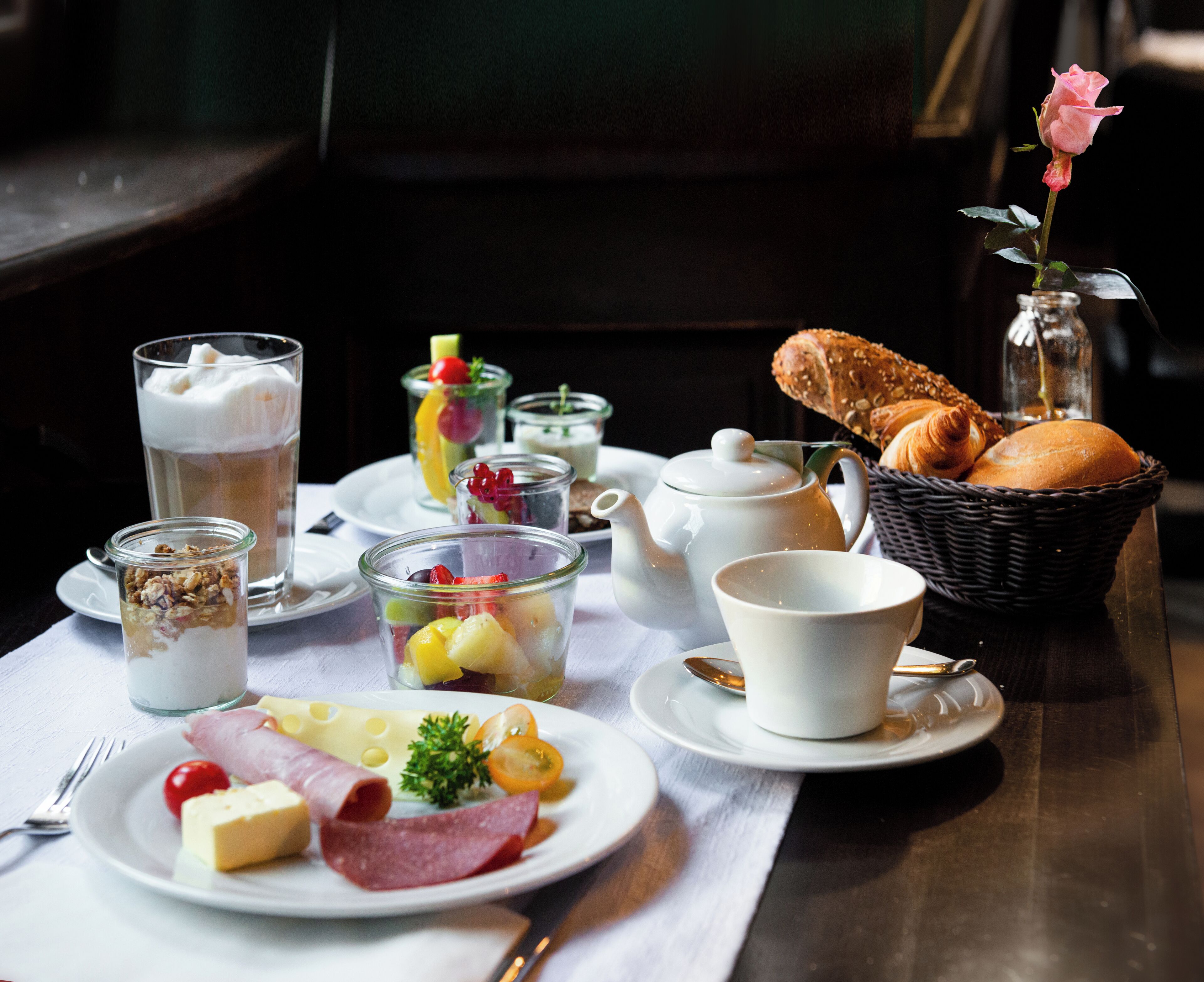 A breakfast setting with various food items and beverages on a table.