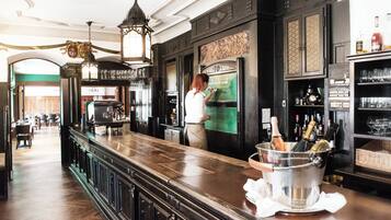 Una zona de bar con mostrador de madera, un enfriador de vinos y una botella de champán.