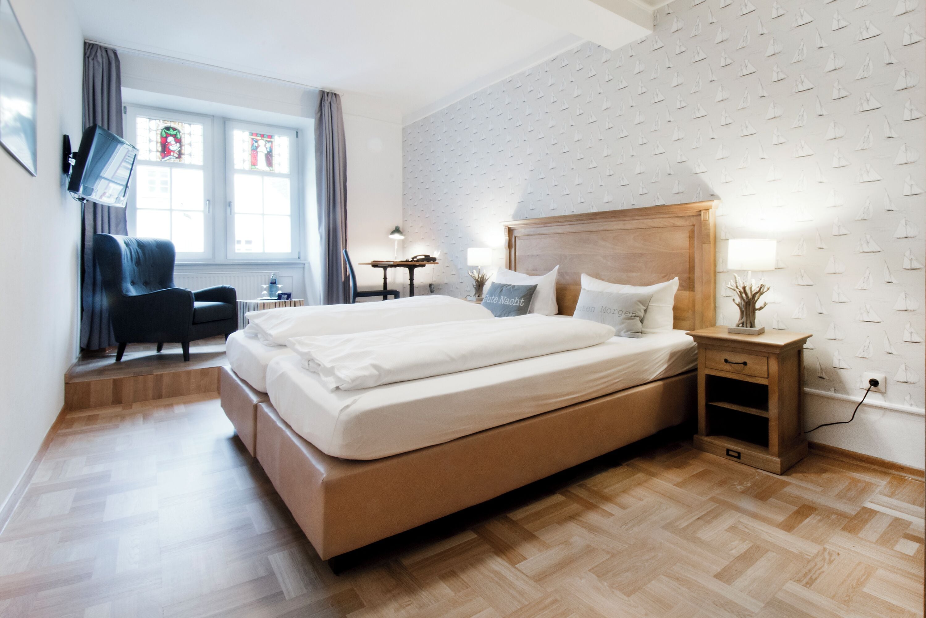 Una habitación de hotel moderna con una cama grande, un escritorio, una silla y una mesita.