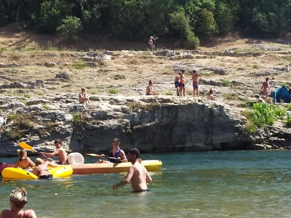 A group of people engaging in water activities near a rocky shore.