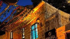 A stone building with a sign reading 'TUNÇ PASA' and a decorative light fixture. - Tunç Paşa Konağı (Mardin)