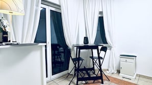 A room with a dining table, chairs, a lamp, a small cabinet, and a radiator. - Spacious Garden Villa | 16 Guests (Vienna)
