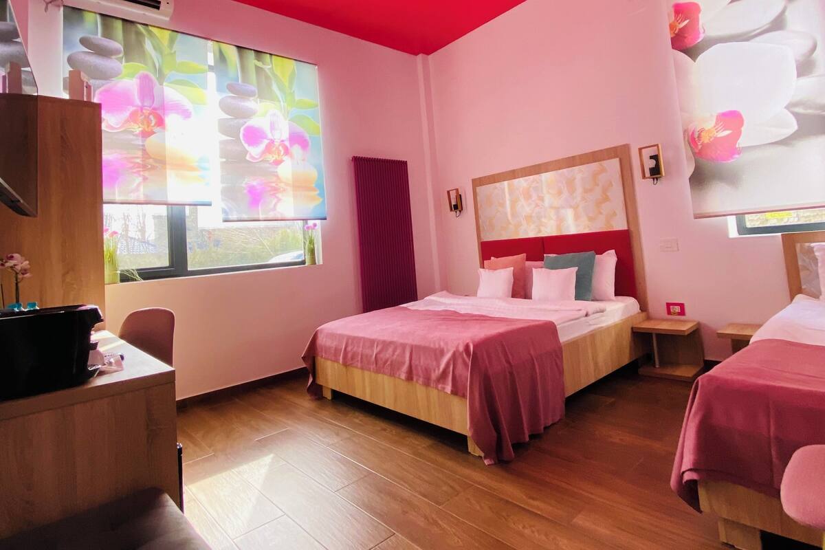 Ein Hotelzimmer mit zwei Betten, einem Schreibtisch und einem Sofa.