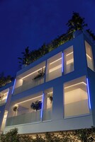 Un moderno edificio a più piani con balconi, ampie finestre ed elementi di illuminazione blu.