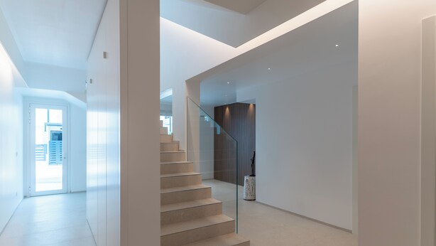 Un intérieur moderne avec un escalier menant à une pièce aux couleurs sombres.