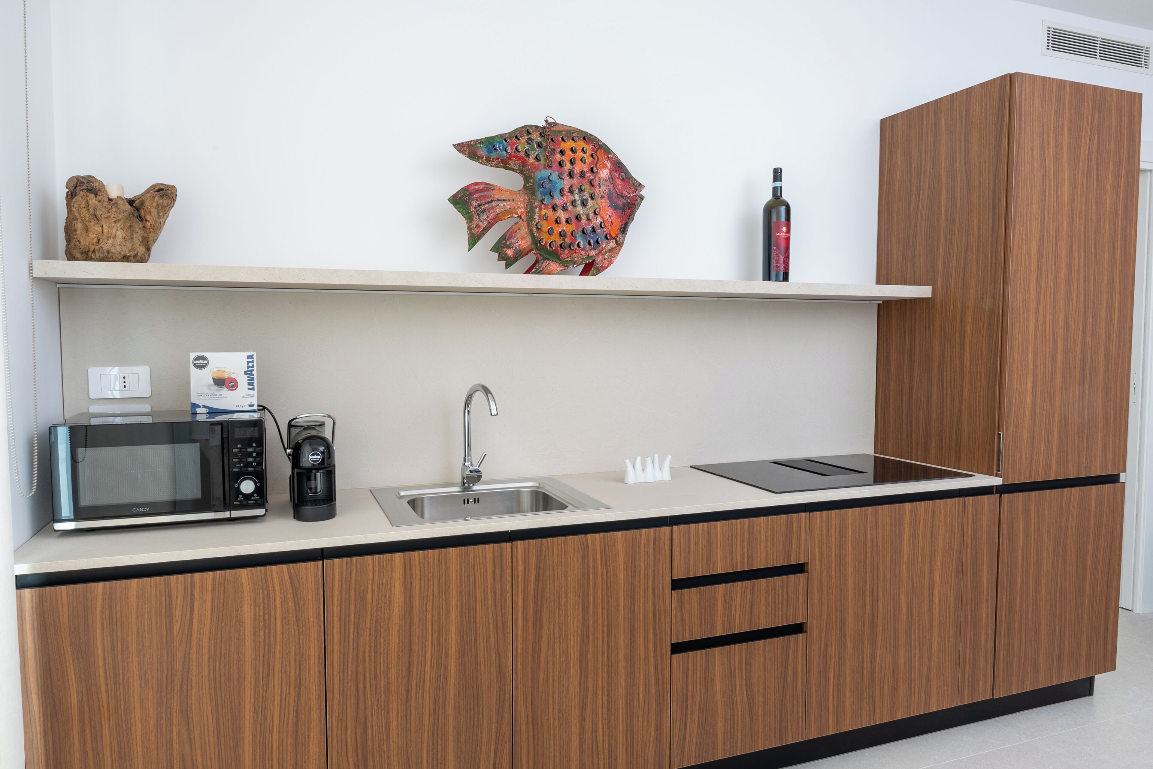 A modern kitchen with a microwave, coffee maker, sink, and wooden cabinets.