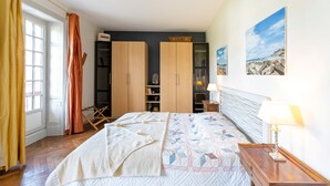 Ein Schlafzimmer mit Bett, Holzschrank und einem Bild an der Wand.