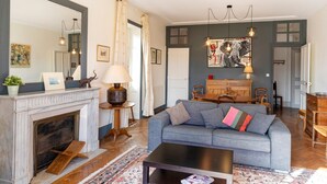 Ein Wohnzimmer mit Kamin, einer Couch, einem Couchtisch und einem Essbereich mit Stühlen und Tisch.