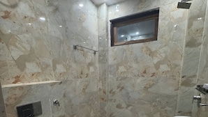 A bathroom with a toilet, a sink, and a shower area. - THE GRAND PALACE (Prayagraj)
