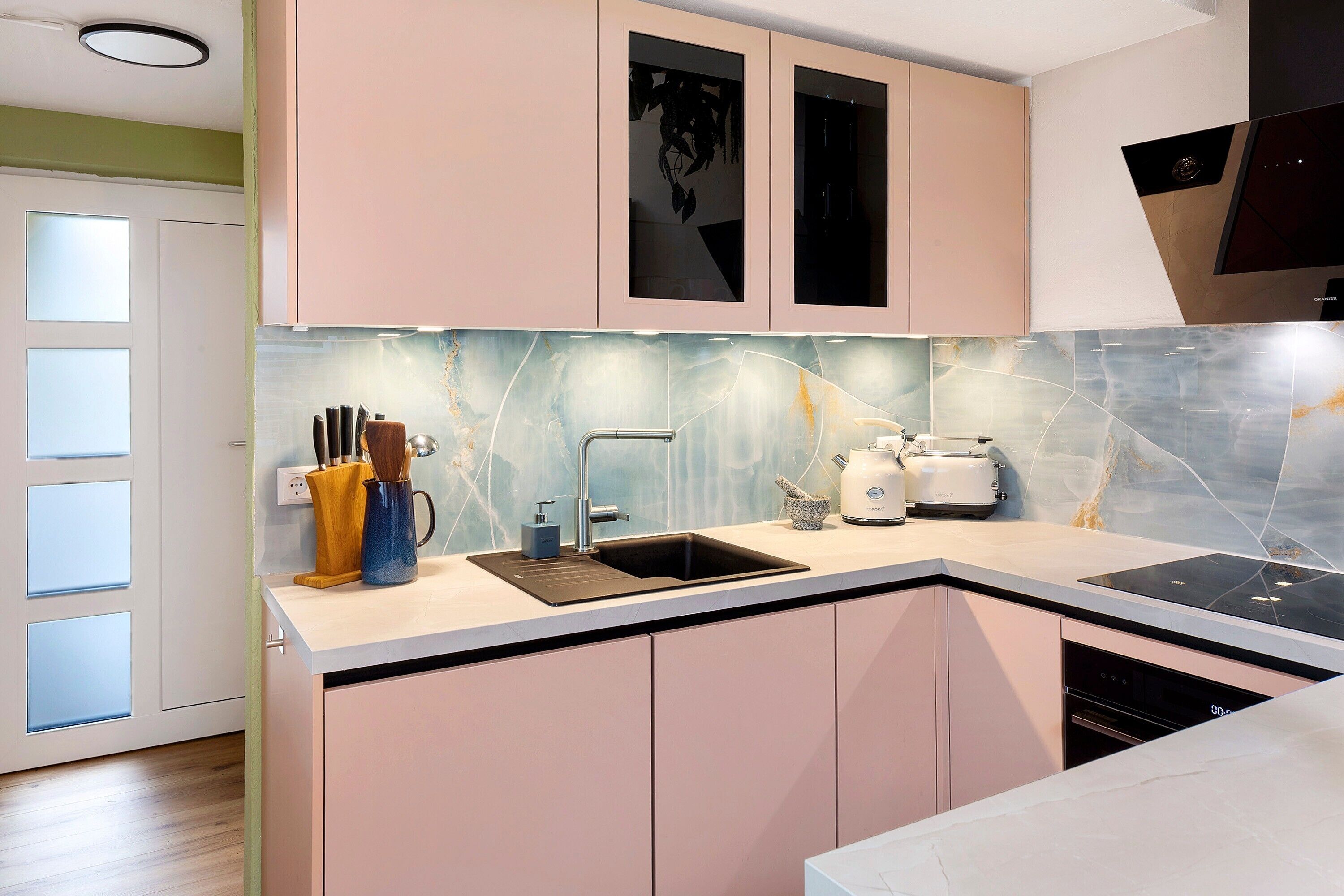 A modern kitchen with a sink, stove, and cabinets.