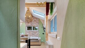 Ein schmales Entree mit Schlafzimmer auf Schlafgalerie, Essbereich und Küche.