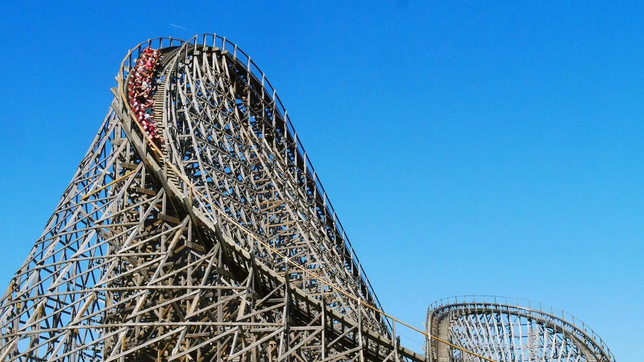 A large roller coaster with a steep incline and a circular track, surrounded by a metal framework.
