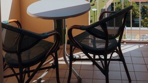 A balcony with a round table and two wicker chairs, overlooking a garden and a view of the sea. - HOTEL ACQUARIO (Marina di Vasto)